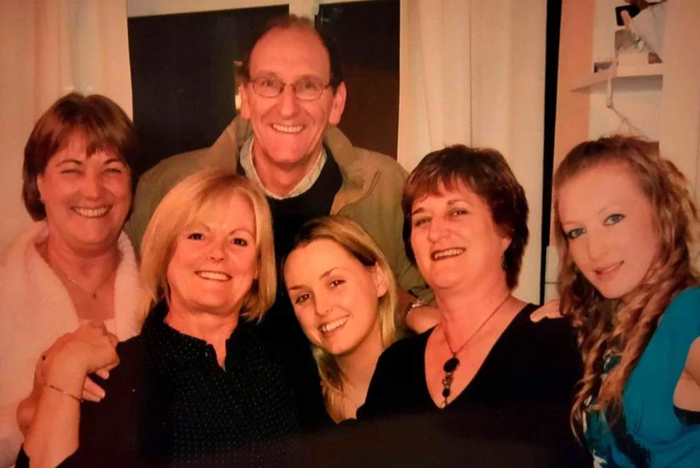 Group photo of five people posing together indoors
